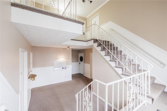 stairway featuring carpet and ornamental molding