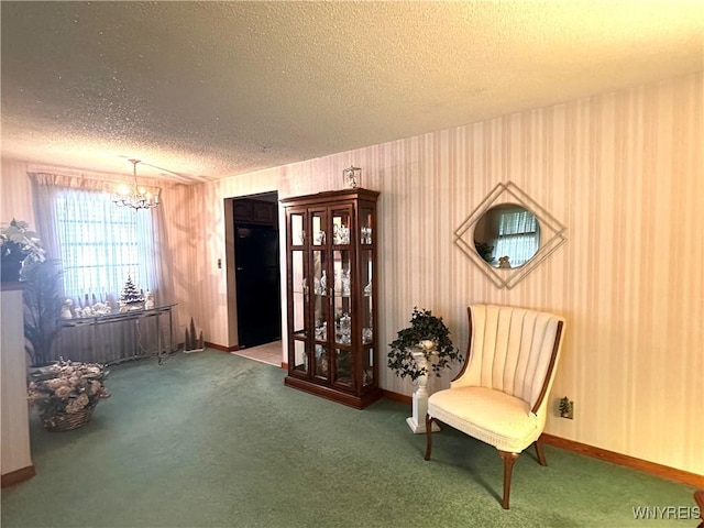 sitting room featuring carpet, a chandelier, and a textured ceiling