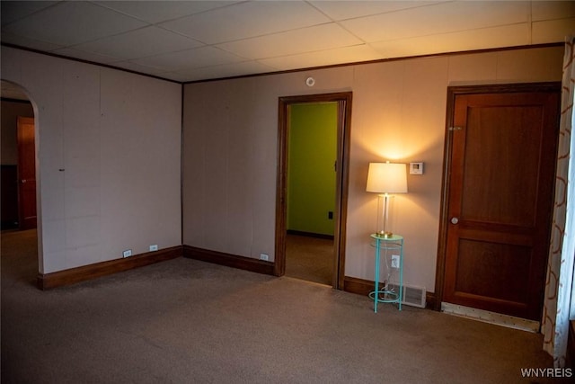 carpeted spare room with a paneled ceiling