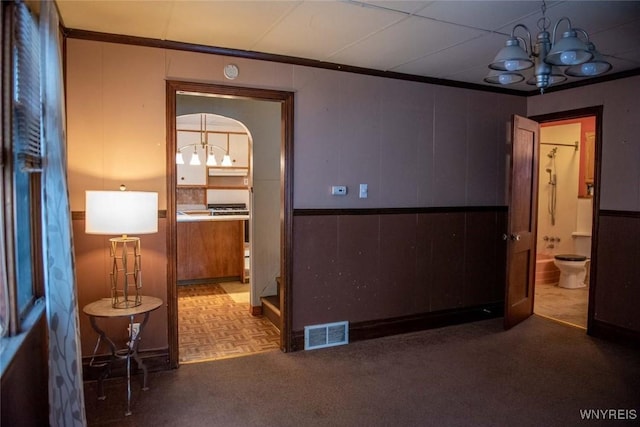 hall with a chandelier and crown molding