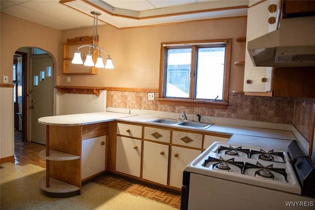 kitchen with light parquet floors, white gas stove, sink, decorative light fixtures, and extractor fan