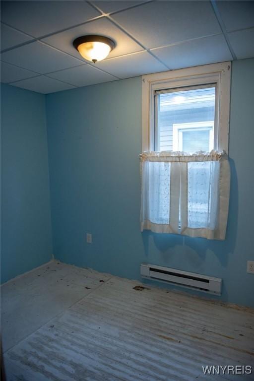 unfurnished room with a paneled ceiling and a baseboard radiator