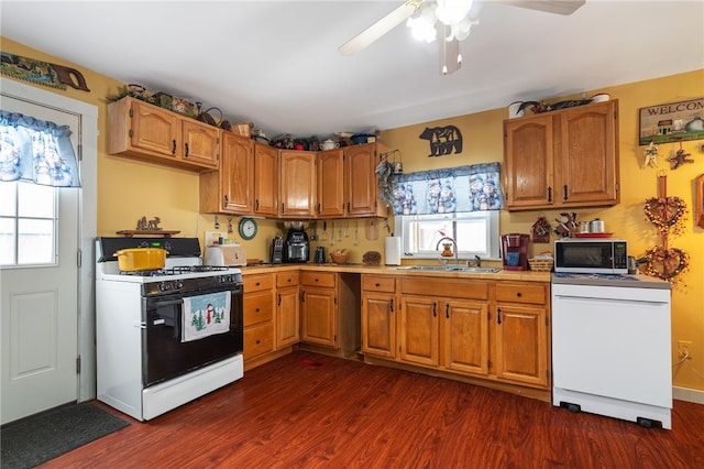 kitchen featuring a wealth of natural light, stainless steel microwave, white range with gas cooktop, and a sink