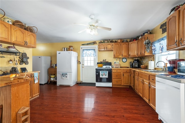 kitchen with freestanding refrigerator, dark wood-type flooring, stove, and gas range