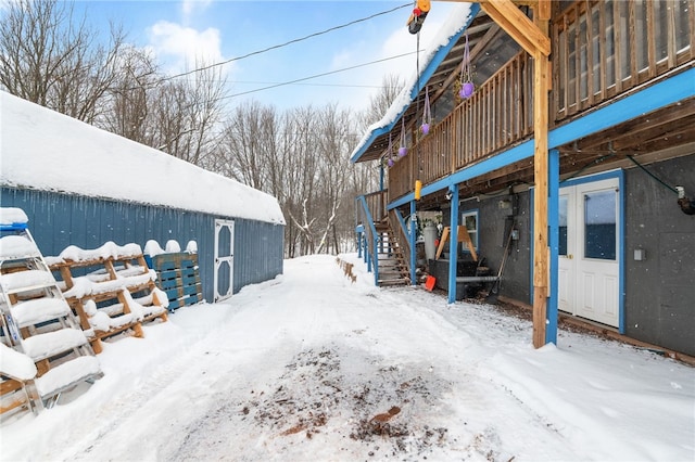 yard covered in snow featuring stairway and a wooden deck