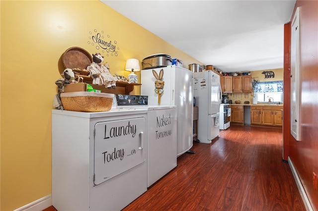 kitchen with dark wood finished floors, freestanding refrigerator, a sink, separate washer and dryer, and stainless steel dishwasher