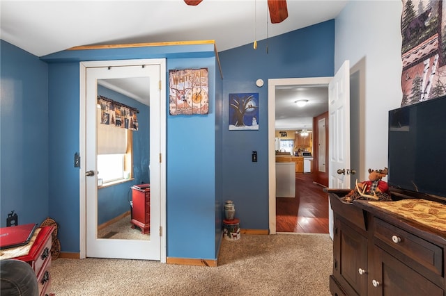 interior space featuring lofted ceiling, multiple windows, a ceiling fan, and baseboards