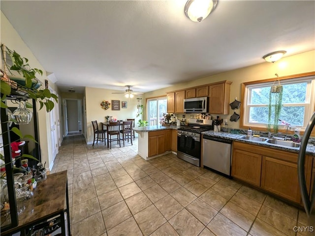 kitchen with kitchen peninsula, ceiling fan, sink, and appliances with stainless steel finishes