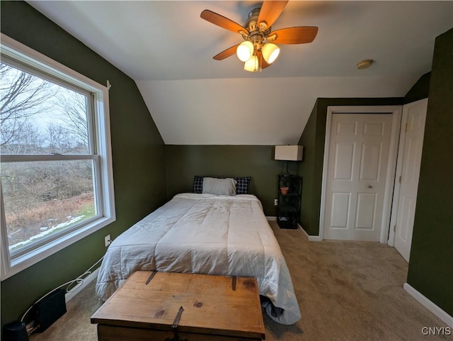 carpeted bedroom featuring vaulted ceiling, multiple windows, and ceiling fan