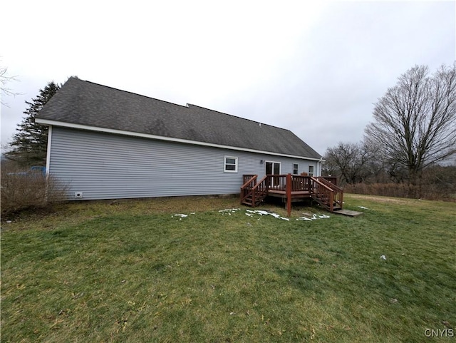 back of house with a deck and a lawn