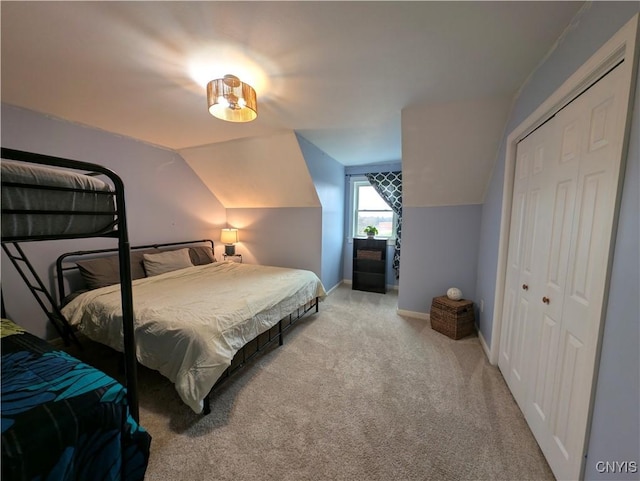 carpeted bedroom featuring a closet and lofted ceiling