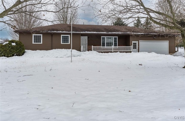 ranch-style house featuring covered porch and a garage