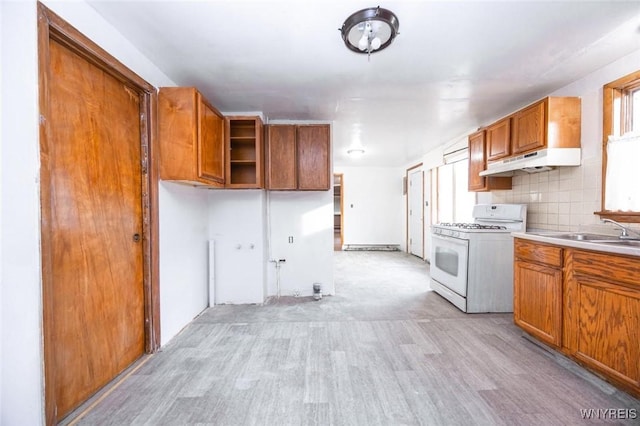 kitchen featuring light hardwood / wood-style floors, white gas range, sink, and tasteful backsplash