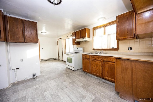 kitchen featuring backsplash, white range with gas stovetop, and sink