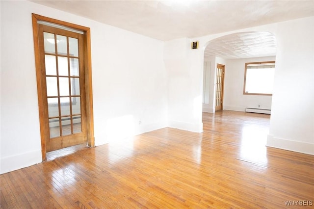 spare room featuring light hardwood / wood-style floors and a baseboard heating unit