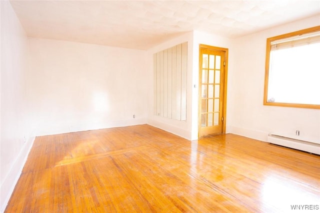 spare room with hardwood / wood-style flooring and baseboard heating