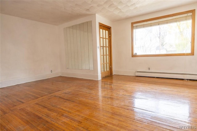 spare room with light wood-type flooring and a baseboard radiator