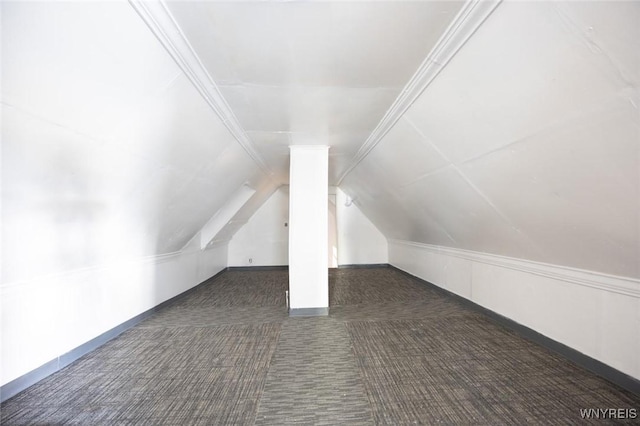 additional living space with dark colored carpet and lofted ceiling