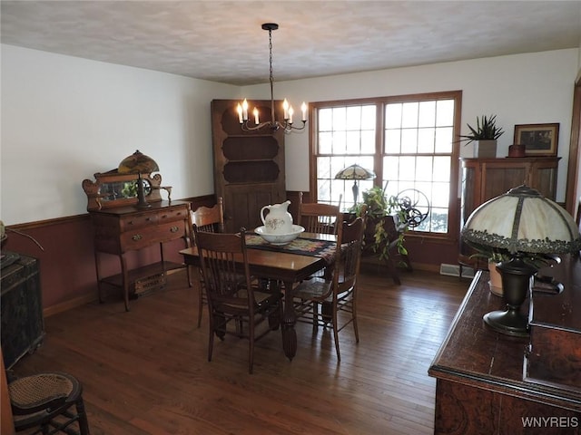 dining room featuring dark hardwood / wood-style floors and an inviting chandelier