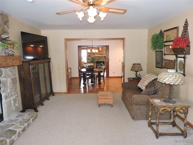 carpeted living room featuring ceiling fan with notable chandelier