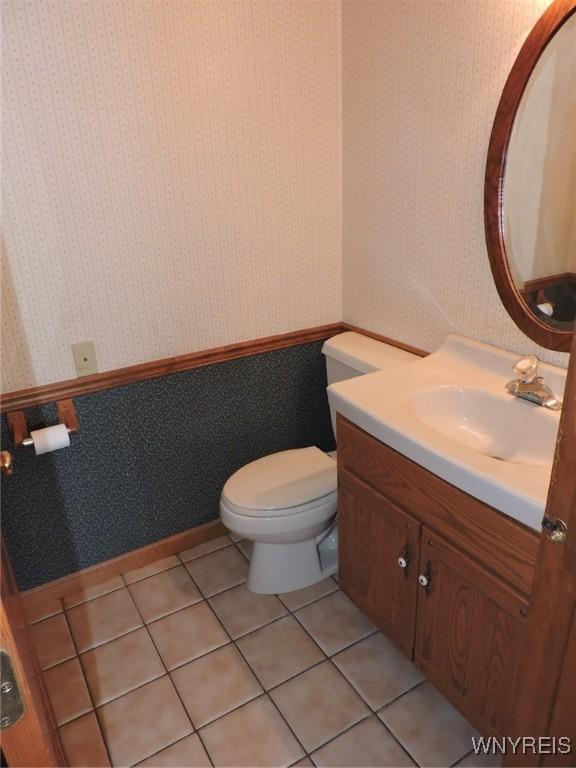 bathroom featuring tile patterned flooring, vanity, and toilet