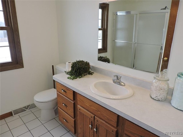 bathroom with tile patterned floors, vanity, toilet, and an enclosed shower