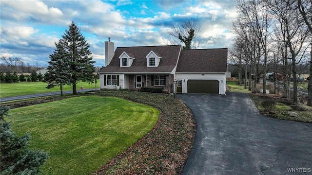 new england style home featuring a front yard and a garage