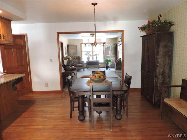 dining area featuring dark wood-type flooring and a notable chandelier