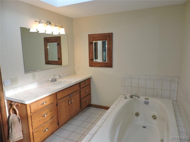 bathroom featuring tile patterned flooring, vanity, a skylight, and tiled bath