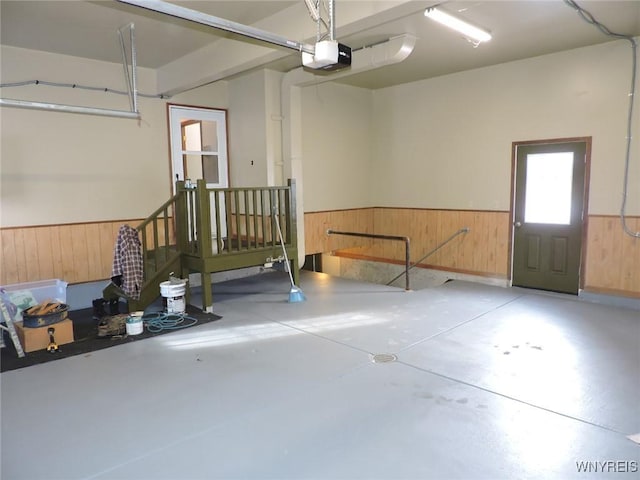 garage with a garage door opener and wooden walls