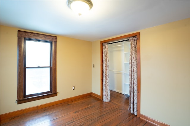 unfurnished room with dark hardwood / wood-style flooring