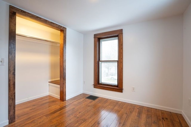 unfurnished bedroom featuring hardwood / wood-style floors and a closet