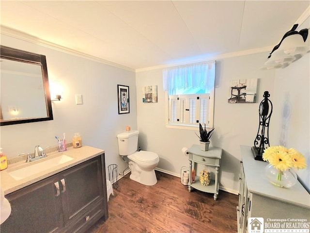 bathroom featuring vanity, toilet, wood-type flooring, and crown molding