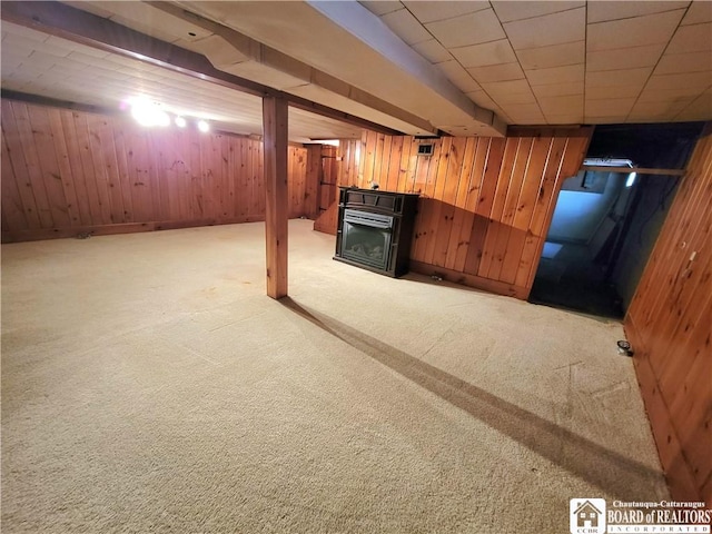 basement featuring light carpet and wooden walls