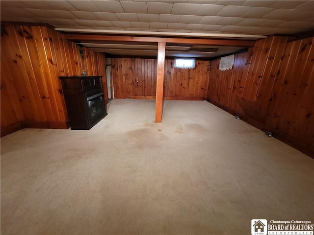 basement featuring light colored carpet and wooden walls