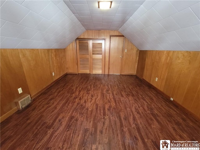 bonus room with wood walls, dark hardwood / wood-style flooring, and vaulted ceiling