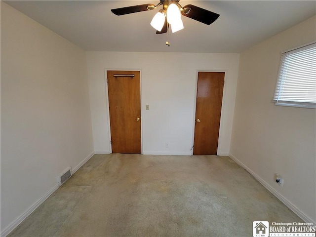 empty room featuring light colored carpet and ceiling fan