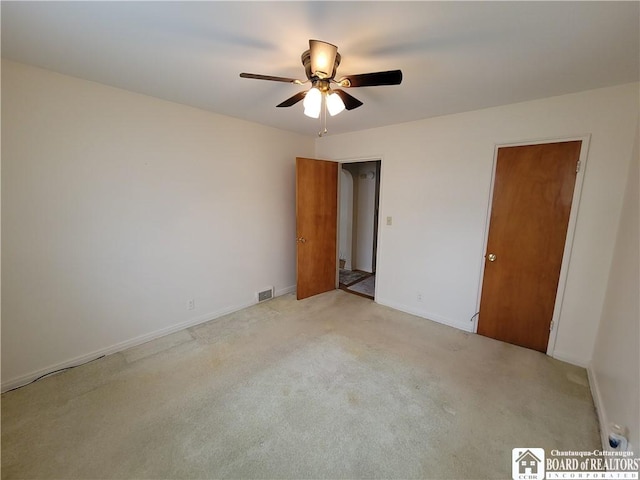 spare room featuring ceiling fan and light colored carpet