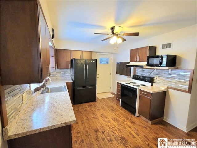 kitchen with sink, light hardwood / wood-style flooring, ventilation hood, decorative backsplash, and black appliances