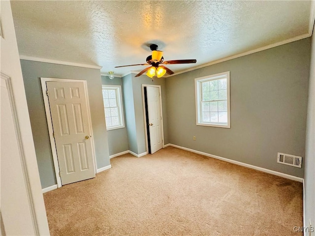 unfurnished bedroom with a textured ceiling, multiple windows, and ceiling fan