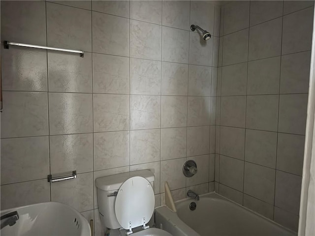 bathroom with tiled shower / bath combo and toilet