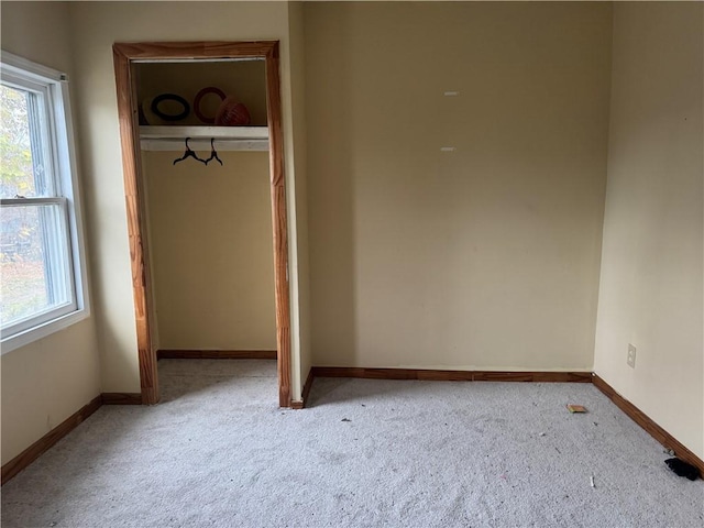 unfurnished bedroom featuring light carpet and a closet