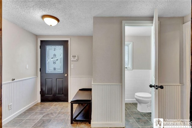 tiled foyer with a textured ceiling