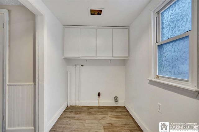 laundry area featuring cabinets, hookup for a washing machine, and light hardwood / wood-style floors