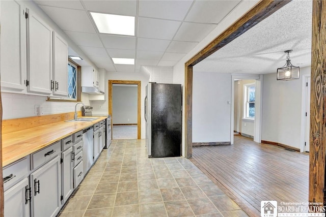 kitchen featuring pendant lighting, sink, tasteful backsplash, white cabinetry, and stainless steel appliances