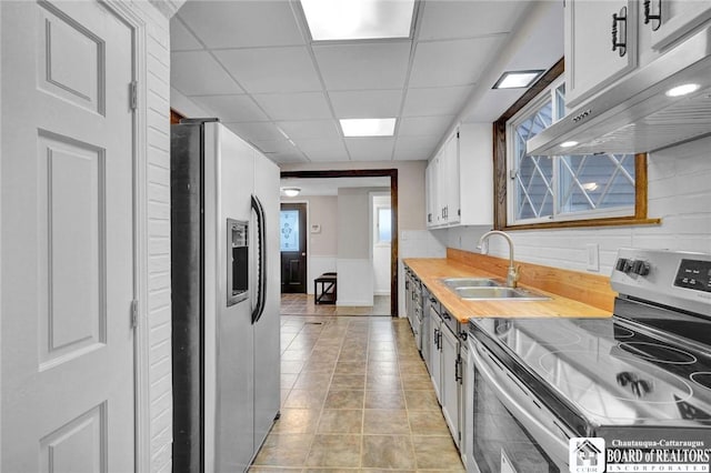 kitchen featuring a drop ceiling, white cabinetry, sink, and appliances with stainless steel finishes