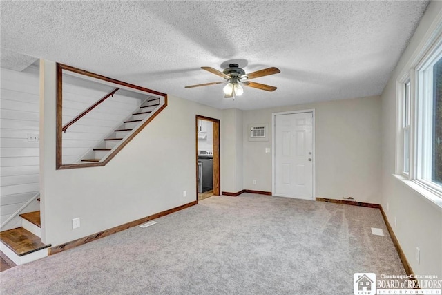 carpeted empty room with ceiling fan and a textured ceiling