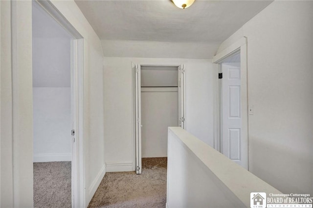 hall featuring light carpet and lofted ceiling