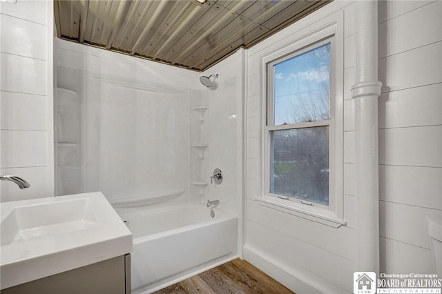 bathroom with plenty of natural light, wood-type flooring, wood ceiling, and bathing tub / shower combination