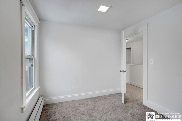 empty room with light colored carpet and a baseboard radiator